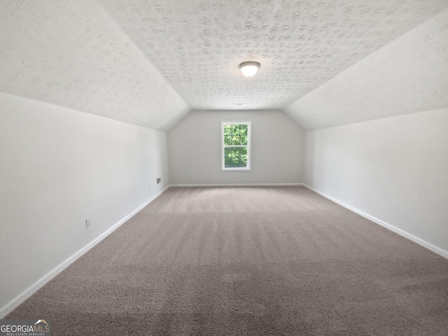 30 Trelawney Ct, Covington, GA 30016 - additional living space featuring baseboards, carpet flooring, a textured ceiling, and lofted ceiling