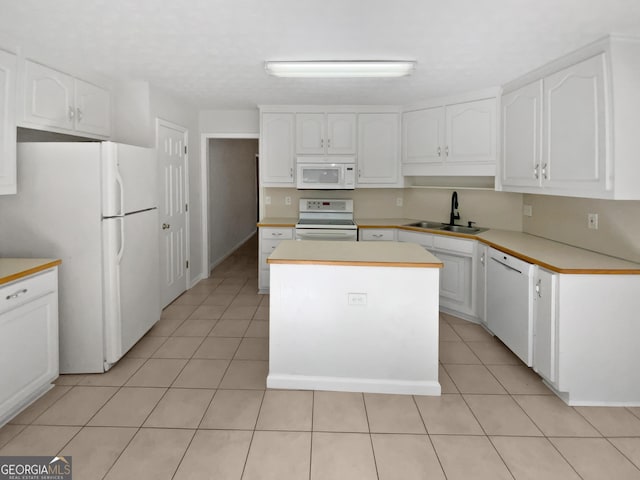 30 Trelawney Ct, Covington, GA 30016 - kitchen featuring a center island, a sink, light tile patterned floors, white cabinets, and white appliances