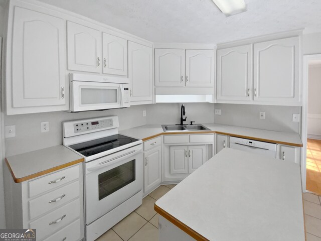 30 Trelawney Ct, Covington, GA 30016 - kitchen with a kitchen island, white appliances, white cabinetry, a sink, and light tile patterned floors