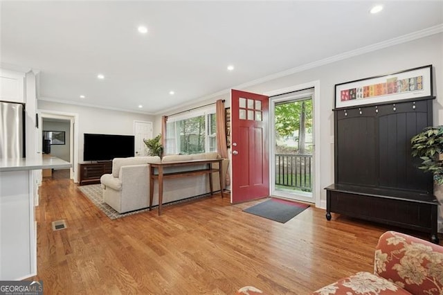 living area featuring recessed lighting, ornamental molding, and light wood-style floors