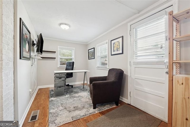home office with baseboards, visible vents, ornamental molding, and wood finished floors