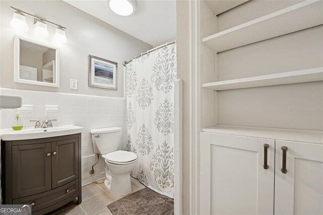 2586 Valley Stream Dr, Atlanta, GA 30360 - full bathroom featuring vanity, tile patterned flooring, a wainscoted wall, tile walls, and a shower with curtain