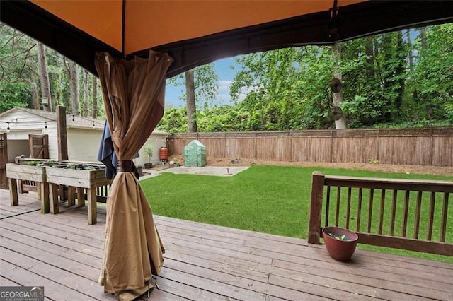 wooden deck with a yard and a fenced backyard