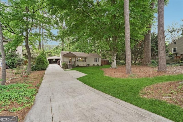 view of front of property with fence, concrete driveway, and a front lawn