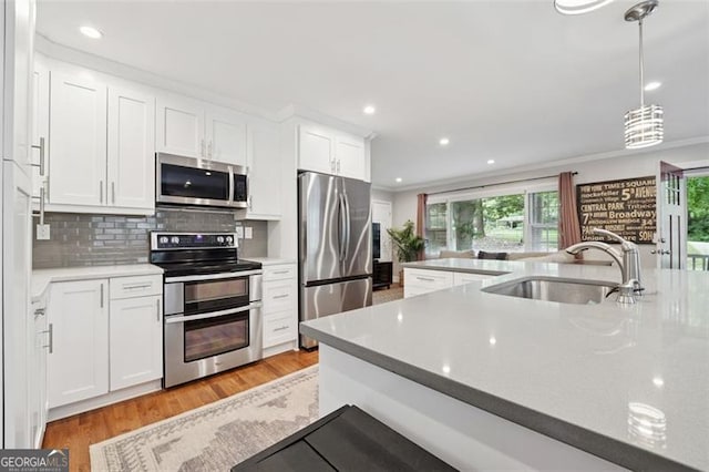 2586 Valley Stream Dr, Atlanta, GA 30360 - kitchen with stainless steel appliances, white cabinets, light wood finished floors, backsplash, and recessed lighting