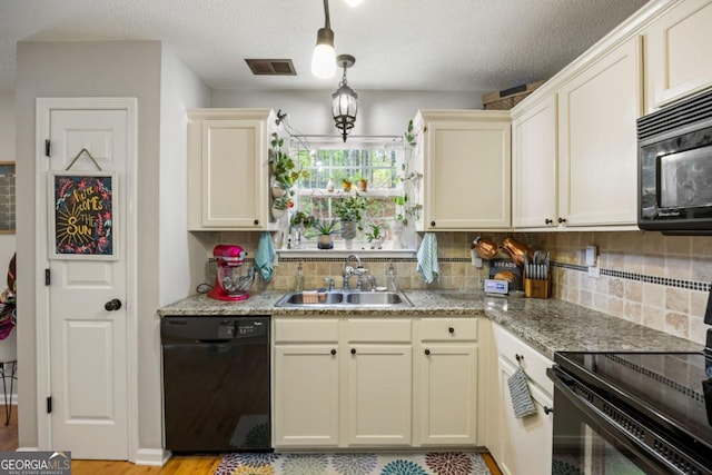 268 Cottonwood Creek Cir, Canton, GA 30114 - kitchen with visible vents, cream cabinets, a sink, backsplash, and black appliances
