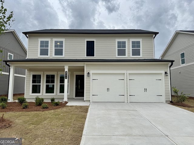 traditional-style house featuring a porch, a garage, a front lawn, and driveway