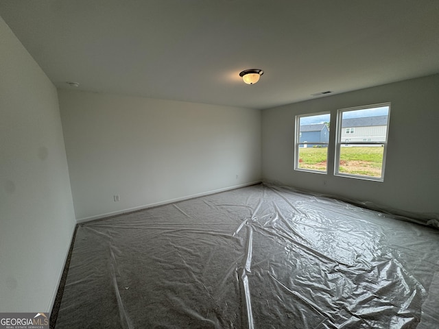 spare room featuring carpet floors, baseboards, and visible vents