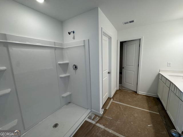 bathroom featuring vanity, baseboards, a stall shower, and visible vents