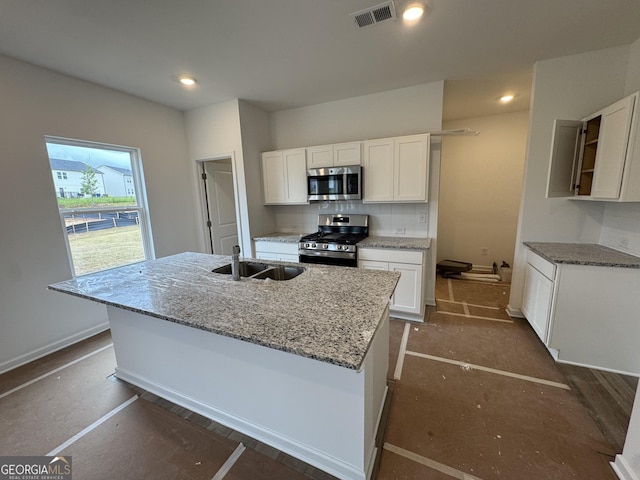 kitchen featuring visible vents, light stone countertops, a sink, white cabinets, and stainless steel appliances