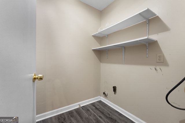 washroom with laundry area, dark wood finished floors, and baseboards