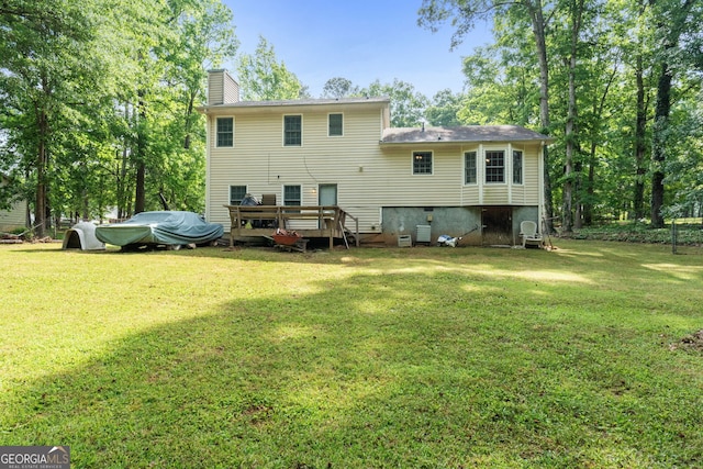 rear view of house with a lawn, crawl space, a chimney, and a wooden deck