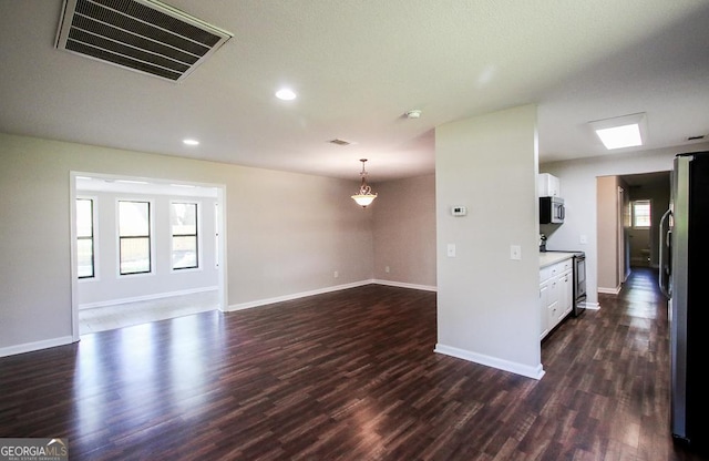 5034 W Ga Highway 292, Collins, GA 30421 - unfurnished living room with dark wood-style flooring, baseboards, and visible vents