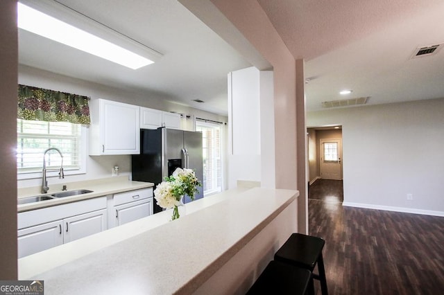 5034 W Ga Highway 292, Collins, GA 30421 - kitchen featuring stainless steel refrigerator with ice dispenser, visible vents, dark wood finished floors, a sink, and white cabinetry
