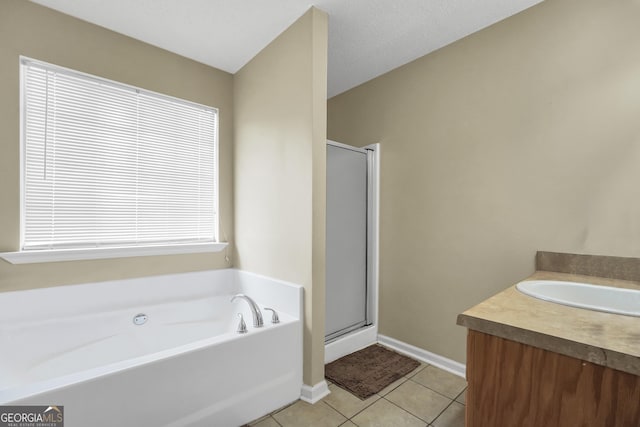 bathroom featuring vanity, tile patterned floors, baseboards, a shower stall, and a bath