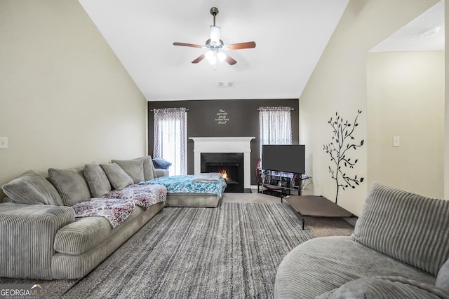 carpeted living room featuring visible vents, ceiling fan, lofted ceiling, and a lit fireplace
