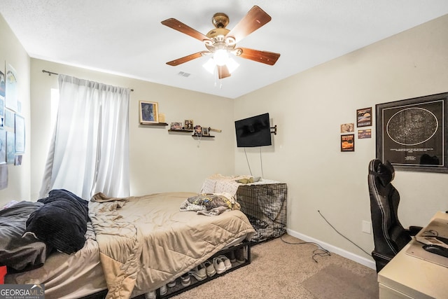 carpeted bedroom featuring baseboards, a ceiling fan, and visible vents
