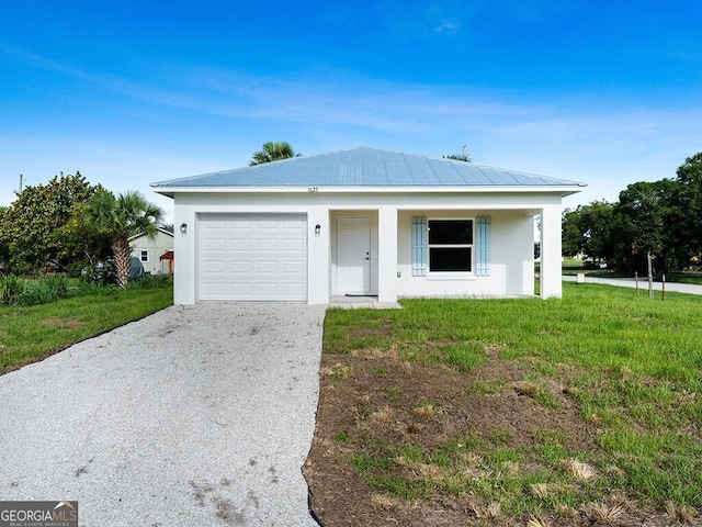 view of front of house with driveway, metal roof, a front lawn, an attached garage, and stucco siding