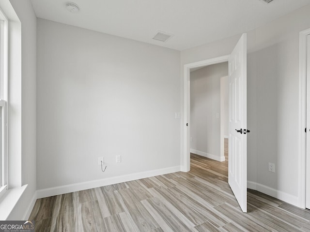 empty room featuring baseboards and light wood-type flooring