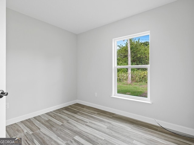 unfurnished room featuring baseboards and wood finished floors