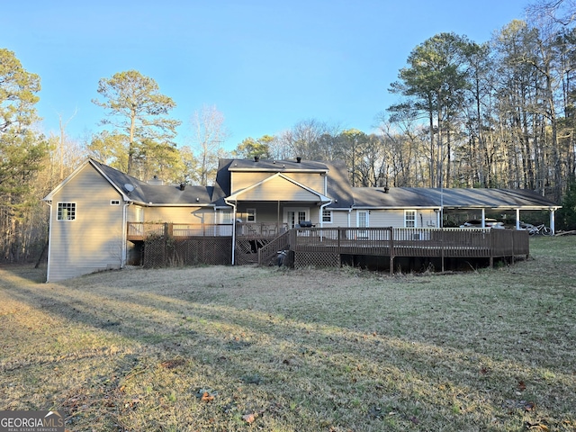 back of house featuring a lawn and a wooden deck