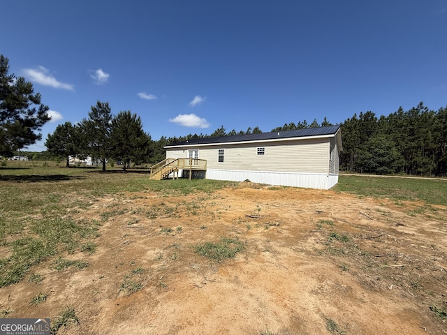rear view of house featuring a wooden deck and stairway