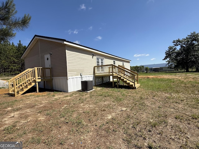 view of side of property with central AC unit, stairs, and a deck