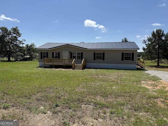 rear view of property featuring a lawn, stairway, a deck, and metal roof