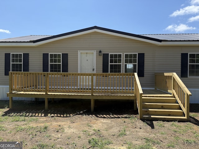 rear view of property featuring metal roof and a deck