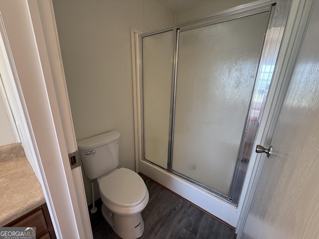 bathroom with a shower with door, toilet, and wood finished floors