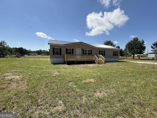 view of front of house with a front lawn, a wooden deck, and metal roof