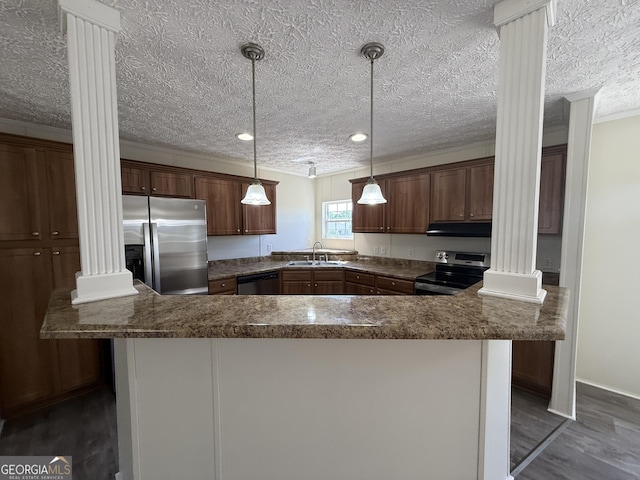 kitchen featuring appliances with stainless steel finishes, a sink, decorative columns, dark wood-type flooring, and ornamental molding