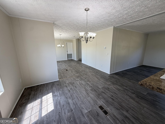 unfurnished dining area featuring a textured ceiling, visible vents, crown molding, wood finished floors, and an inviting chandelier