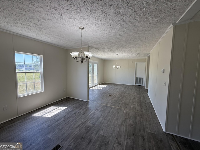 spare room with dark wood-type flooring, a textured ceiling, a chandelier, and visible vents