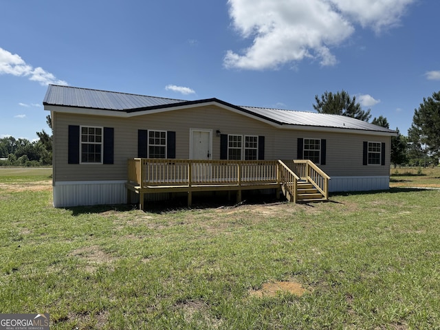 view of front of property with a deck, metal roof, and a front yard