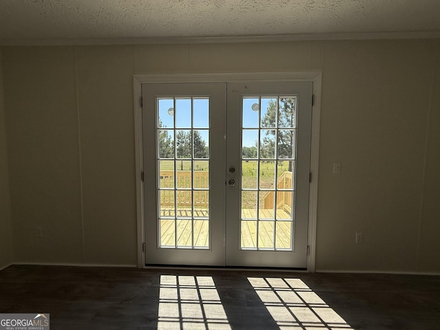 doorway featuring french doors, ornamental molding, a textured ceiling, and wood finished floors