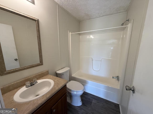 full bathroom featuring a textured ceiling, wood finished floors, vanity, toilet, and tub / shower combination