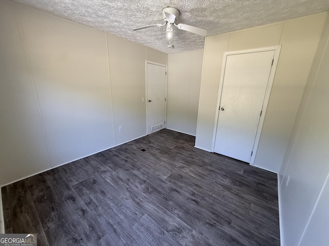 unfurnished bedroom with visible vents, a ceiling fan, a textured ceiling, and dark wood finished floors