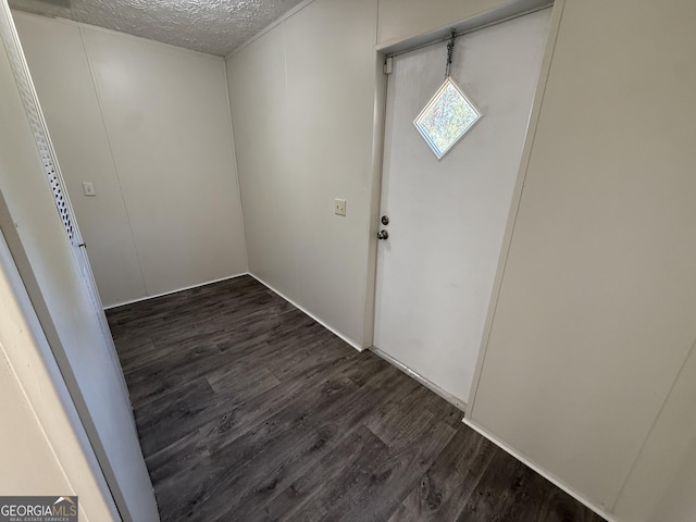 entryway with dark wood-style flooring and a textured ceiling