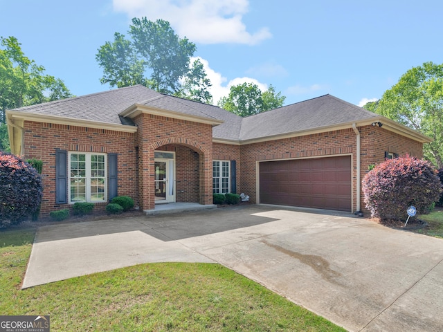 single story home featuring a front lawn, brick siding, a shingled roof, an attached garage, and driveway