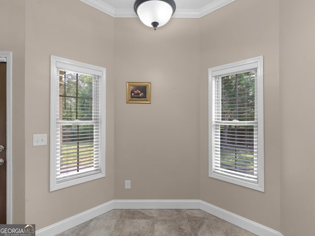 spare room with crown molding and baseboards