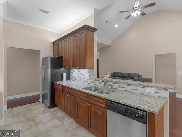 kitchen featuring light stone counters, a sink, stainless steel appliances, a ceiling fan, and decorative backsplash