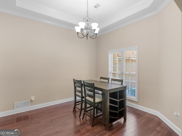dining area featuring visible vents, ornamental molding, dark wood-style flooring, a raised ceiling, and a notable chandelier