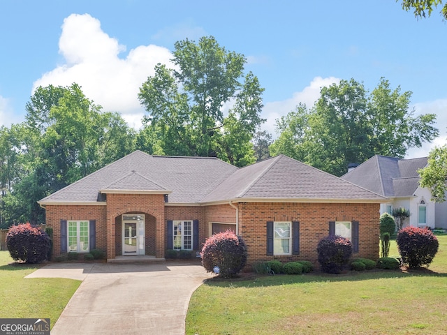 single story home with brick siding, a front lawn, roof with shingles, and driveway
