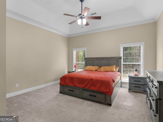 bedroom featuring a tray ceiling, visible vents, light carpet, and ornamental molding