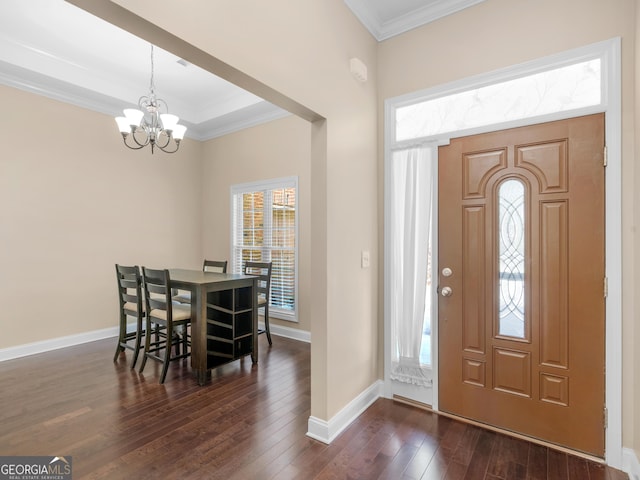 entrance foyer with an inviting chandelier, a wealth of natural light, ornamental molding, and dark wood-type flooring