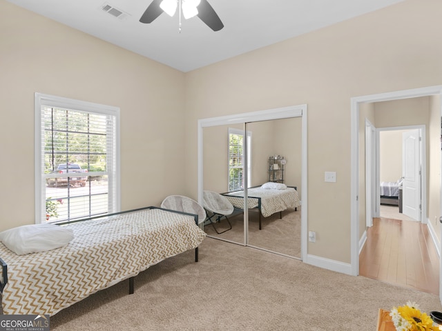 carpeted bedroom featuring visible vents, baseboards, a closet, and multiple windows