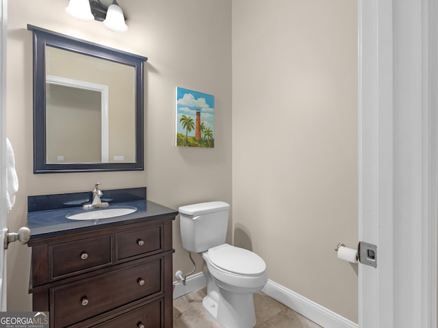 bathroom featuring baseboards, tile patterned floors, vanity, and toilet