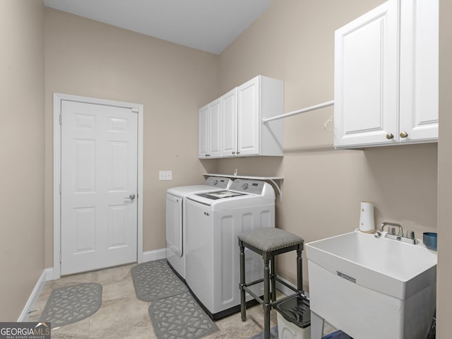 laundry area with a sink, baseboards, cabinet space, and washer and clothes dryer