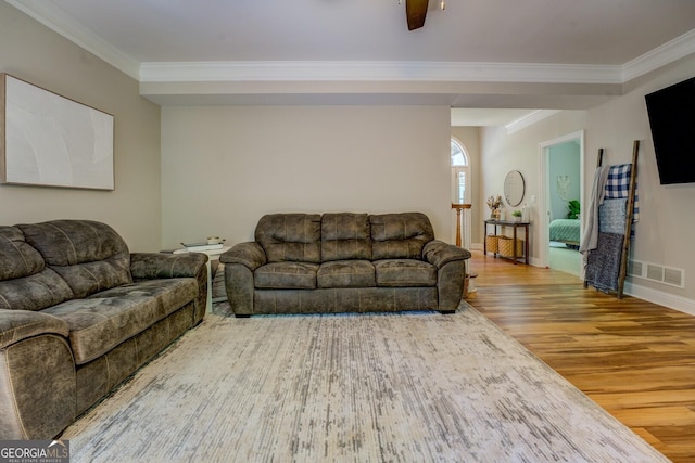 living room featuring wood finished floors, crown molding, and baseboards